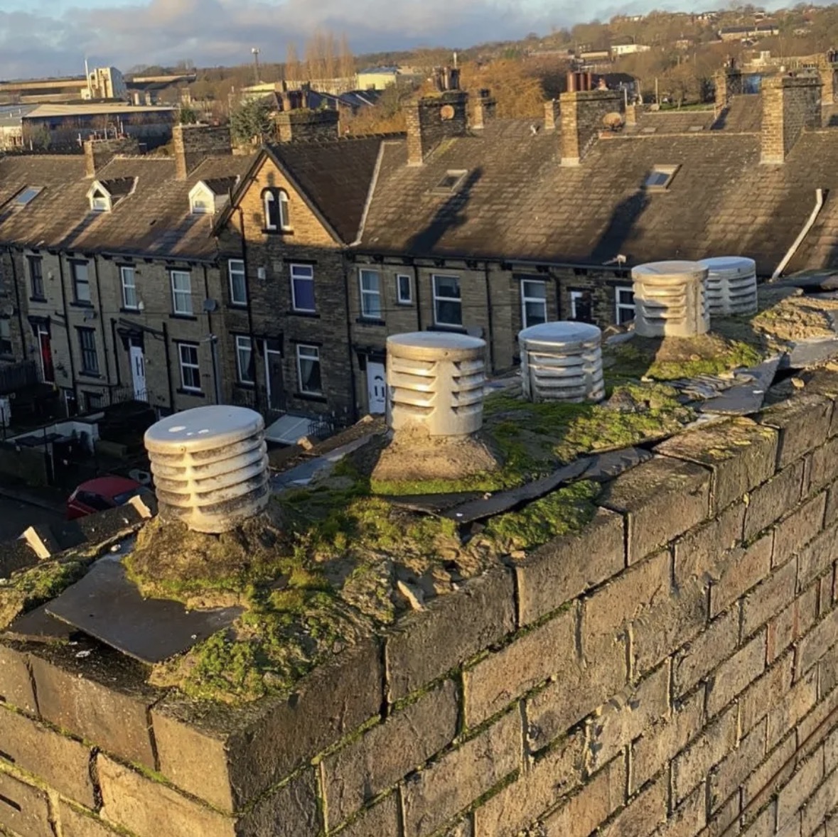 Chimney stack with cracked, mossy flaunching before repair